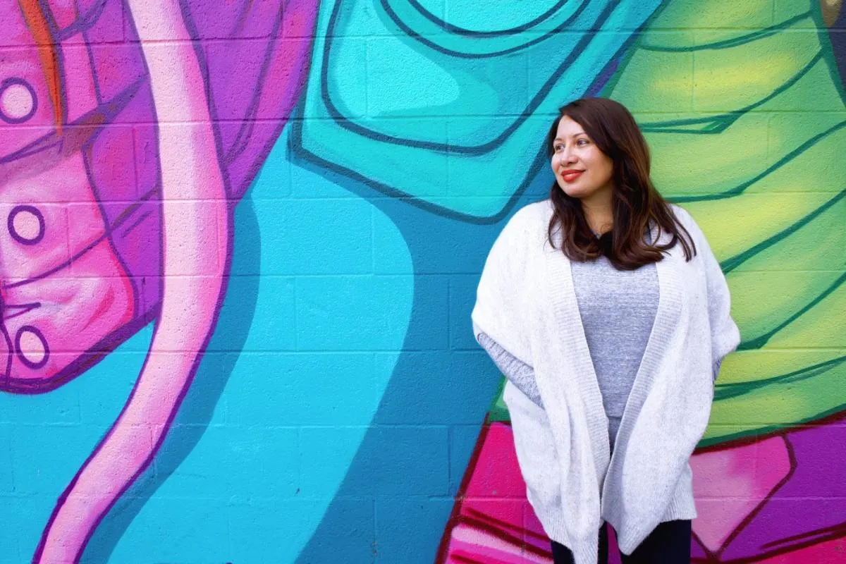 Sofia Mendoza, LCSW, standing in front of a brightly painted mural